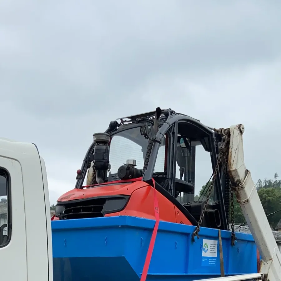 Beladener blauer Absetzcontainer mit einem Stapler auf dem Lkw von AZ Containerdienst